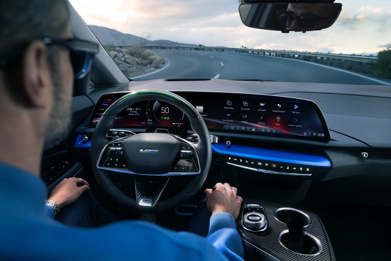 Front View of the 2026 OPTIQ-V Driving Through the Dusk Utilizing its Headlights | Bergstrom Cadillac of Manitowoc in MANITOWOC WI